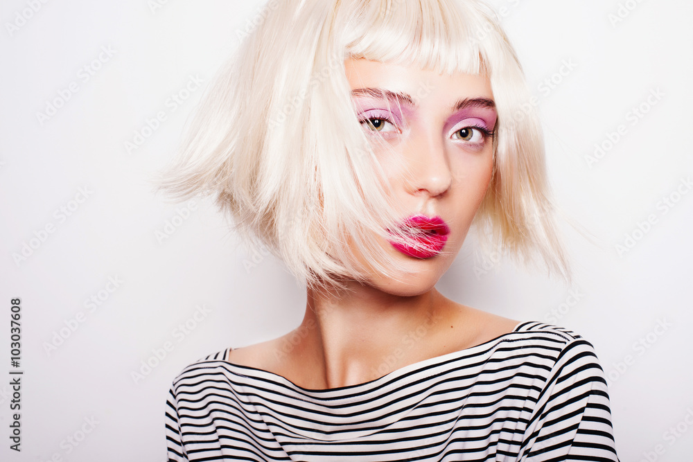 Portrait of an attractive young blond woman in a striped dress in studio on a white background Portrait of an attractive young blond woman in a striped dress in studio on a white background