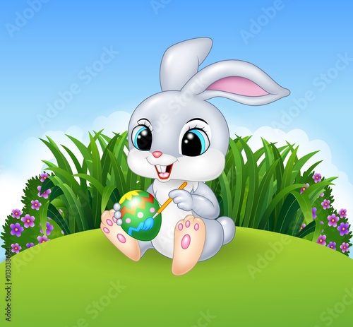 Cartoon Easter Bunny painting an egg in the jungle 