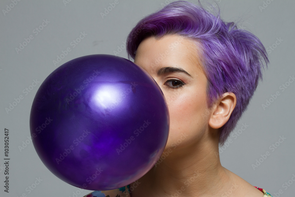 Closeup of violet short-haired woman holding a balloon with her Closeup of violet short-haired woman holding a balloon with her