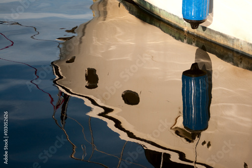 Waterlines - The bow of a boat is reflected in the marina waters at Tarpon Springs' Sponge Docks.