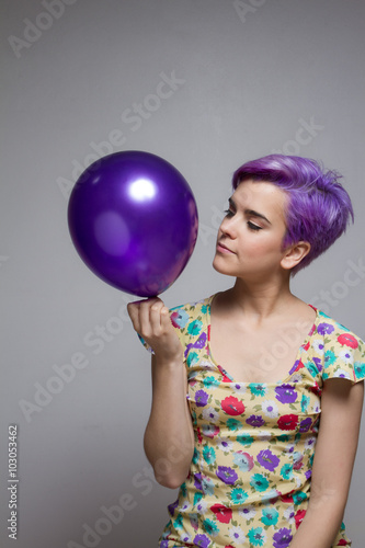 Violet short-haired woman holding a balloon with her hand, watch