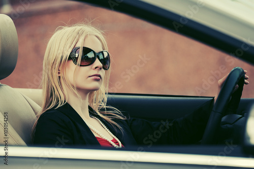 Young fashion woman in sunglasses driving convertible car © Wrangler