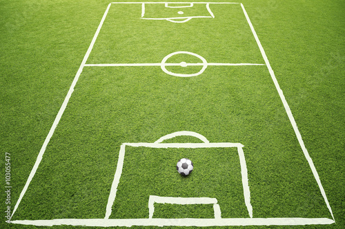 Beautiful sketched soccer field with soccer ball on sunny grass background. © robsonphoto
