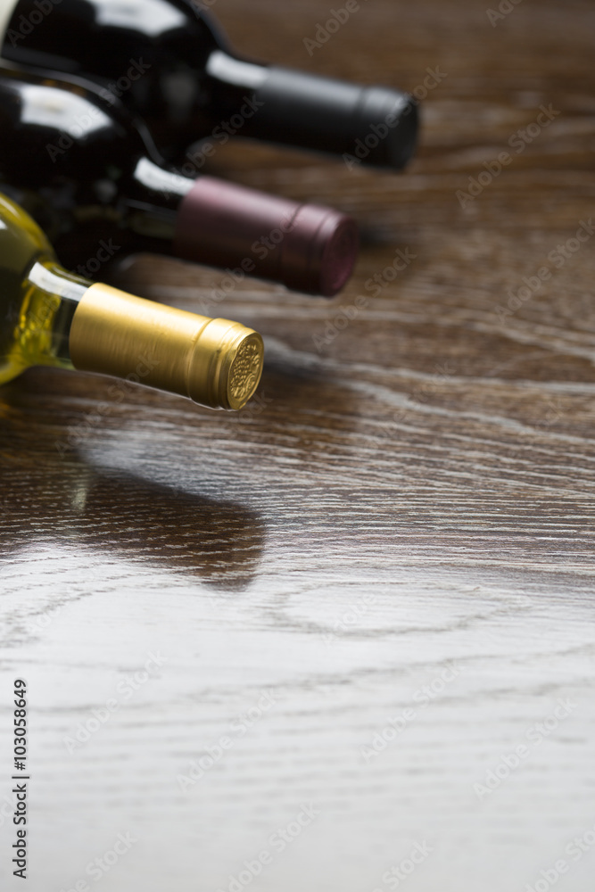 Various Wine Bottles on Reflective Wood Surface Abstract