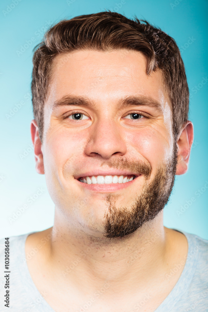 Fototapeta premium Szczęśliwy człowiek z brodą na wpół ogoloną twarzą.