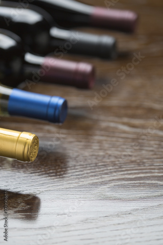 Various Wine Bottles on Reflective Wood Surface Abstract