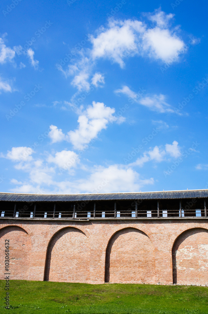 Brick wall with sky, clouds and green grass Brick wall with sky, clouds and green grass
