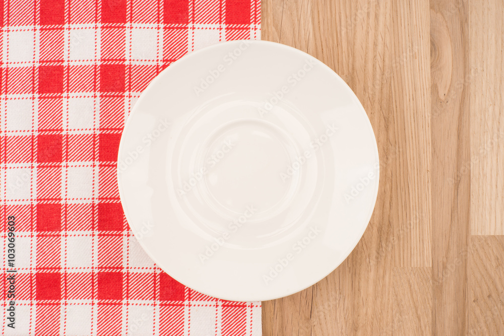 Empty plate on wooden tabletop with tablecloth Empty plate on wooden tabletop with tablecloth