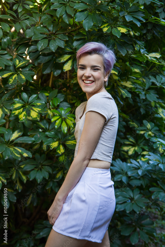 Violet short-haired woman outdoors laughing at camera. Violet short-haired woman outdoors laughing at camera.