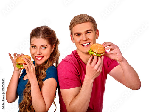 Young couple man and woman back to back and eating hamburgers  . Fastfood concept.  Isolated.