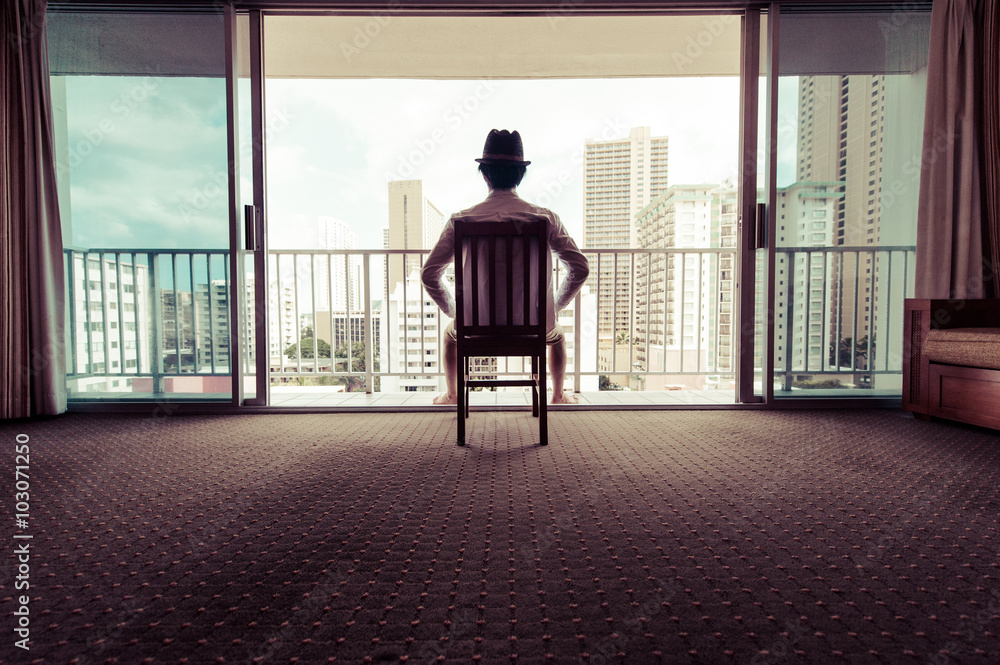 Fototapeta premium 椅子に座って窓から景色を眺める男性