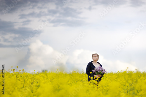 A woman in a flower field with a bouquet. © PAstudio
