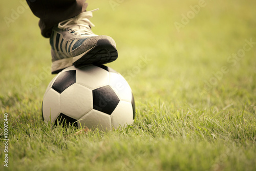 Close up of feet on top of soccer ball © sirikorn