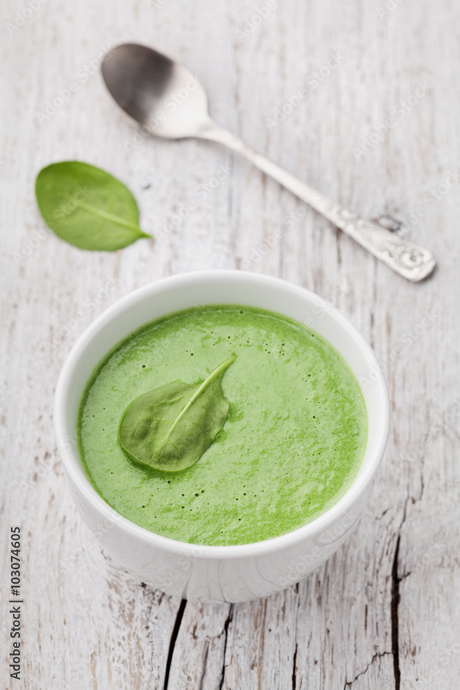 Spinach cream soup in bowl on white rustic table, top view Spinach cream soup in bowl on white rustic table, top view