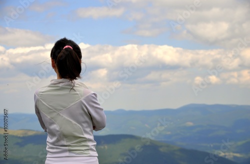 Girl on the top of a mountain and looks into distance