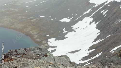 View from the mountain plateau at the lake on the canyon bottom, melting icefields. Khibiny massif, Kolsky peninsula, Russia
 photo