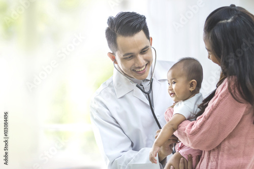 baby being checked by a doctor photo