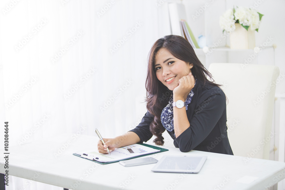 Young smiling business woman working on her paperwork Young smiling business woman working on her paperwork