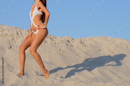 girl in a bikinigoes on sand