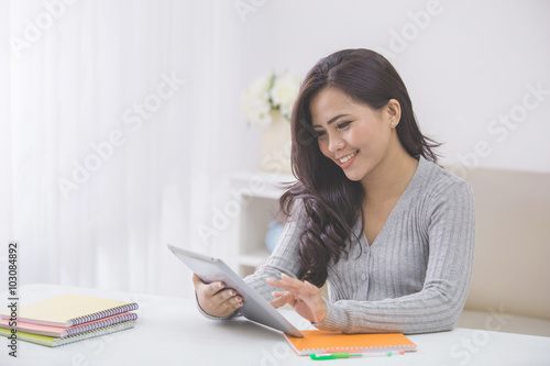 asian female student at home using tablet