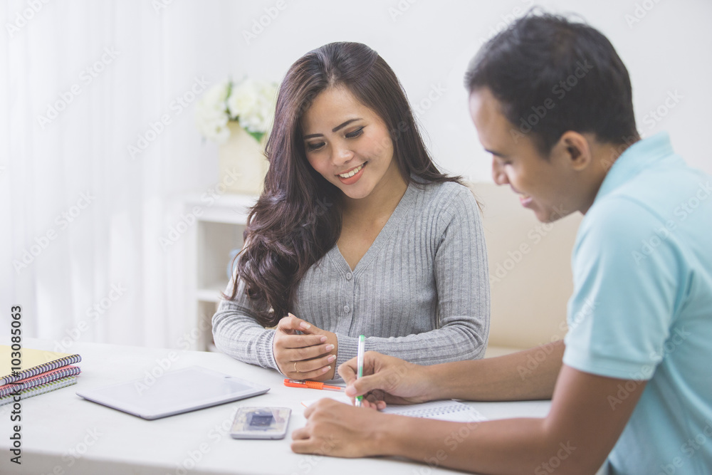 asian female and male student studying together at home asian female and male student studying together at home