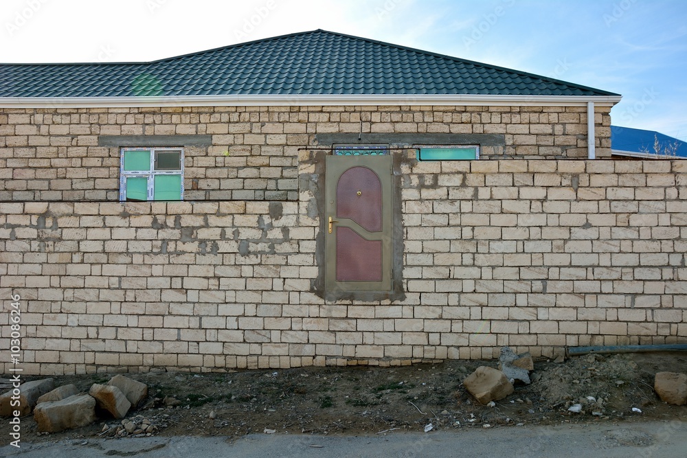 Fototapeta premium Door in unfinished building standing above ground level. A funny looking stage in building, appearing as though the architect has made a mistake 