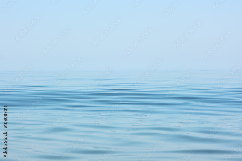 Obraz premium Spokojna powierzchnia morza. Pejzaż morski we wczesnych godzinach porannych pod bezchmurnym niebem.