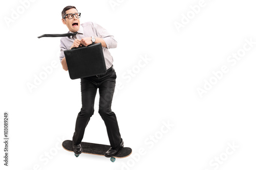 Scared businessman riding a skateboard