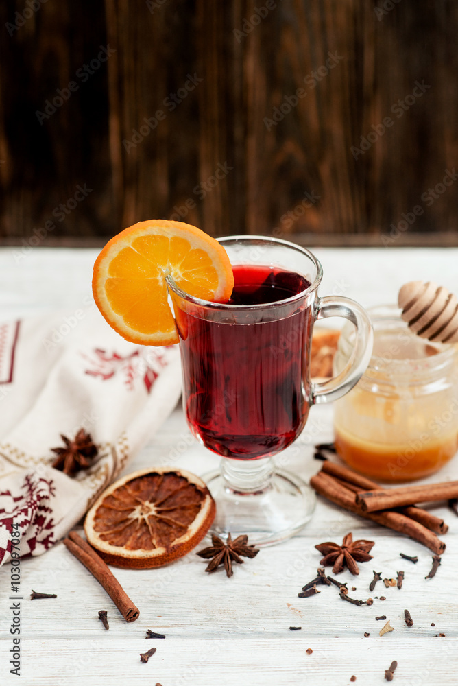 mulled wine with oranges , honey , cinnamon and cloves on a wooden background
mulled wine with oranges , honey , cinnamon and cloves on a wooden background