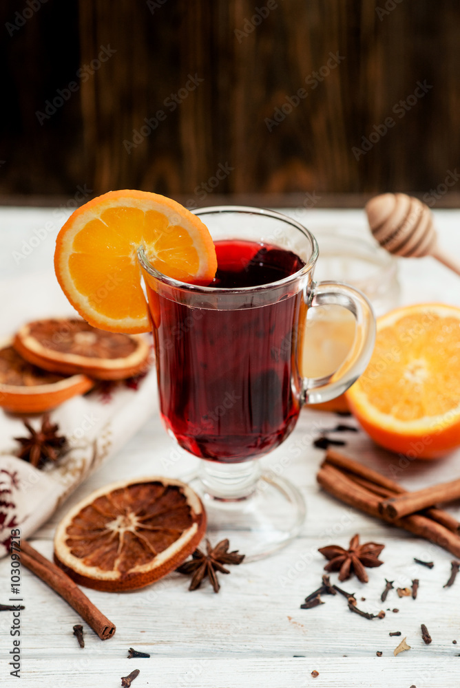 mulled wine with oranges , honey , cinnamon and cloves on a wooden background
mulled wine with oranges , honey , cinnamon and cloves on a wooden background