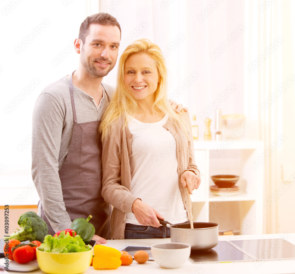 Young attractive couple cooking in a kitchen Young attractive couple cooking in a kitchen