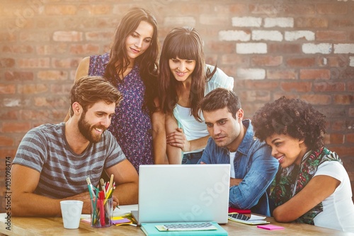 Composite image of happy creative business team gathered around 