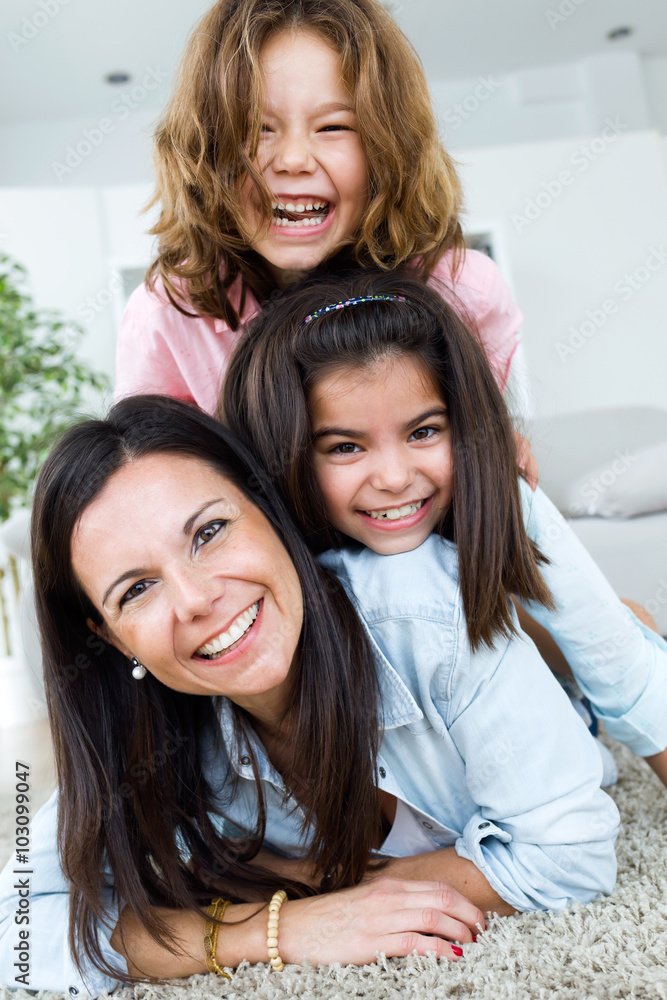 Beautiful mother with her daughters looking at camera at home. Beautiful mother with her daughters looking at camera at home.