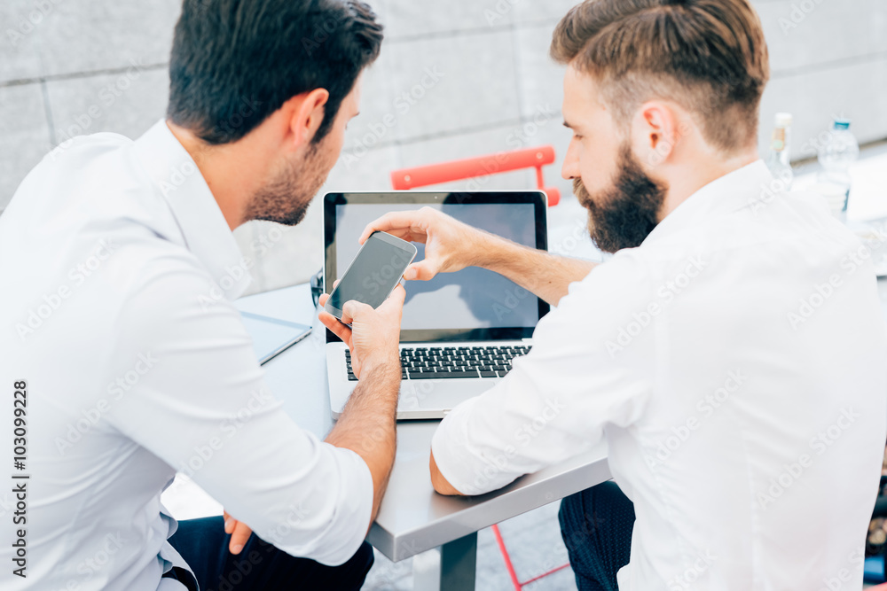 Obraz premium Two young bearded caucasian modern business man sitting in a bar
