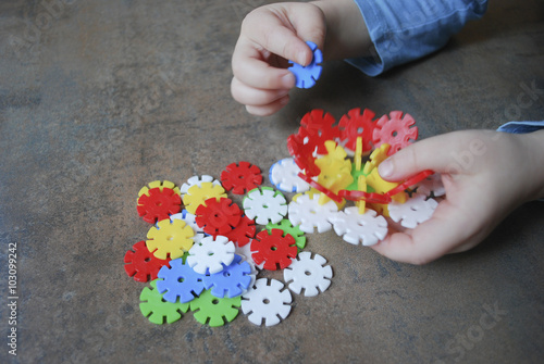 Children hands holding flower from puzzles for children.
