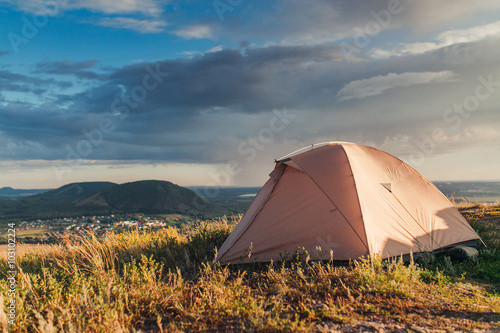 Majestic sunrise in the mountains landscape. Lonely tent on a mo