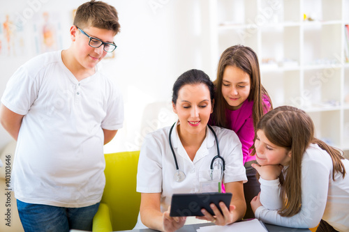 Female doctor and patient teenagers discussing health issues. Medical examination.