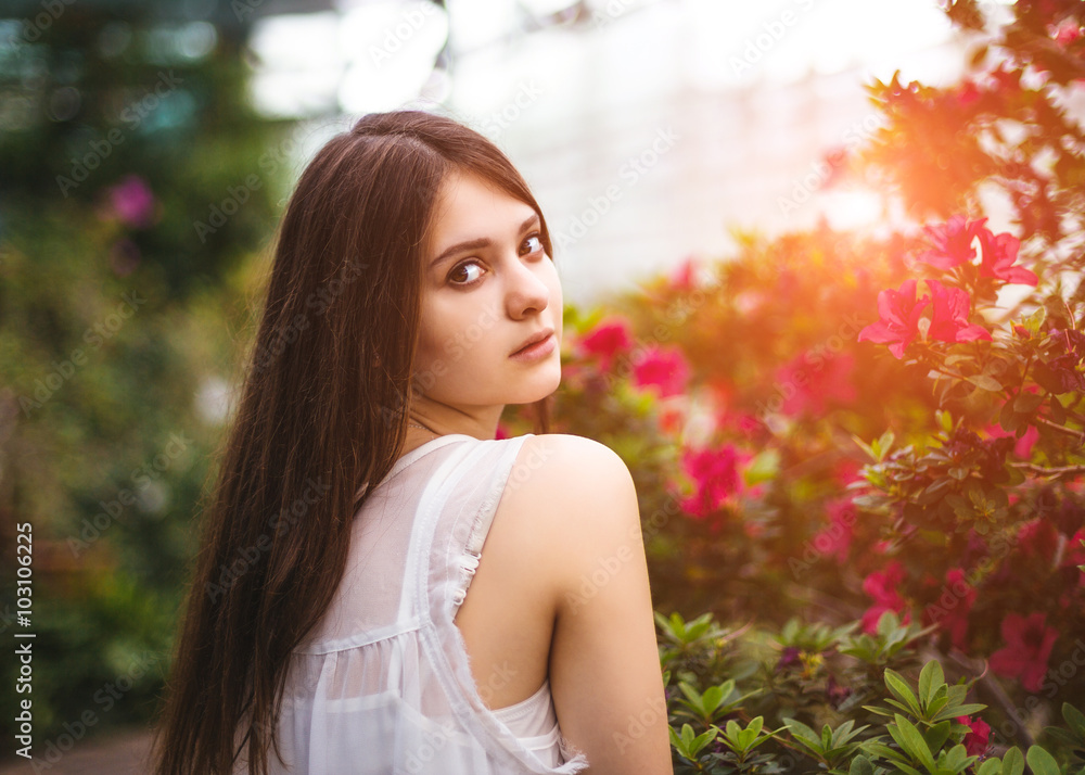 Young pretty girl posing near beautiful leaves and flowers Young pretty girl posing near beautiful leaves and flowers