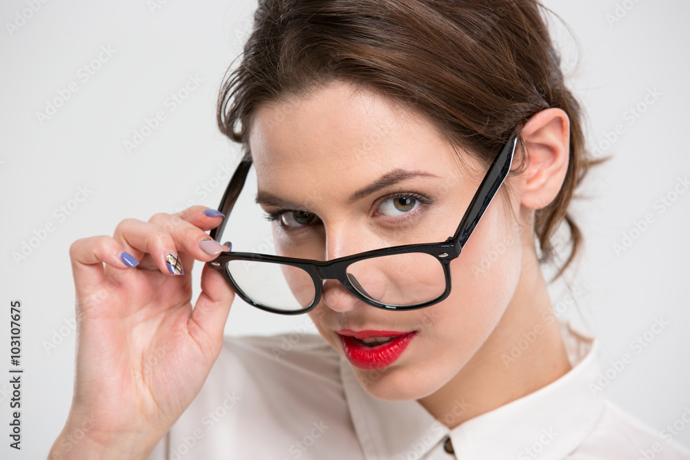 Sensual beautiful business woman with red lips looking over glasses Sensual beautiful business woman with red lips looking over glasses