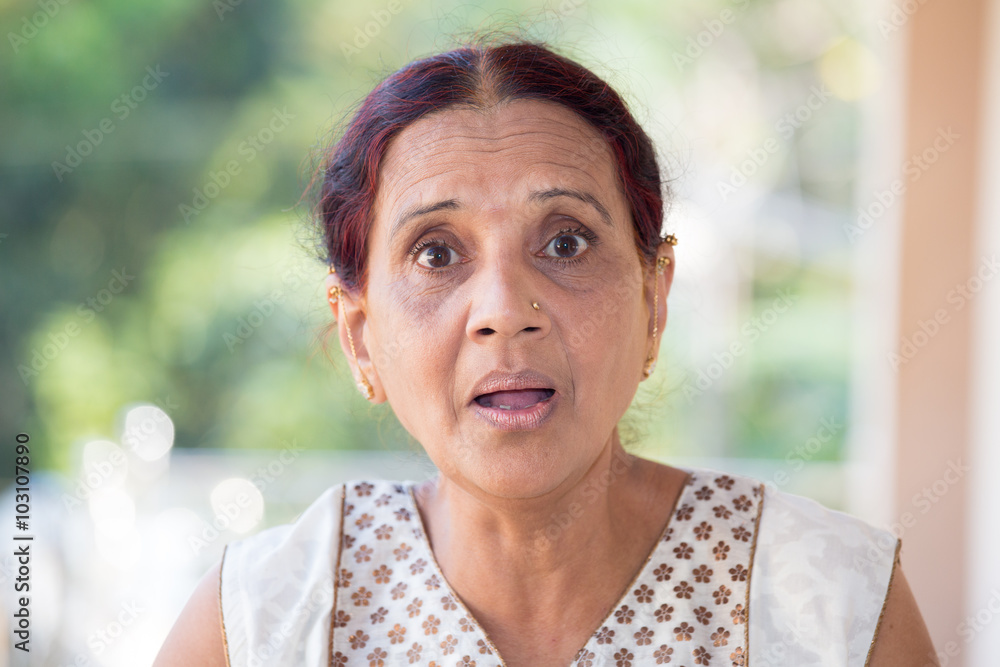 Closeup portrait, elderly woman in white dress taken aback, blown away, by what she sees or hears, isolated outdoors outside background with green trees Closeup portrait, elderly woman in white dress taken aback, blown away, by what she sees or hears, isolated outdoors outside background with green trees