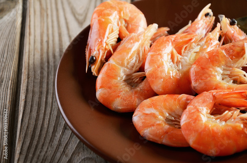 boiled shrimp on a plate on a wooden background close-up