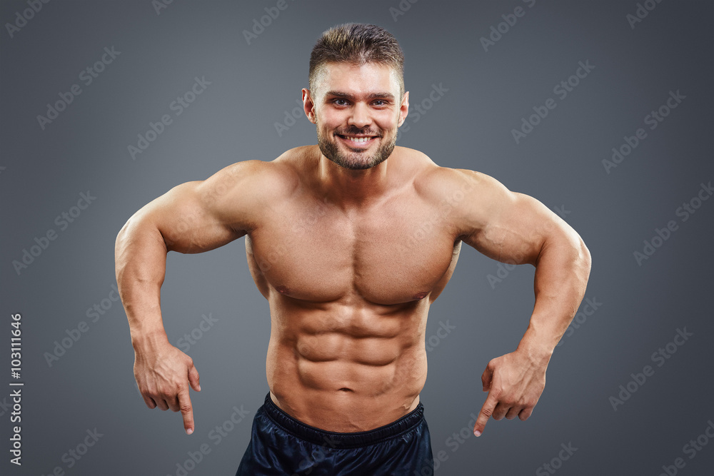 Smiling muscular man pointing down Smiling muscular man pointing down