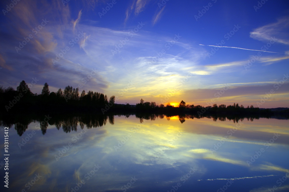 Dramatic evening sky over lake, tranquil nature scene