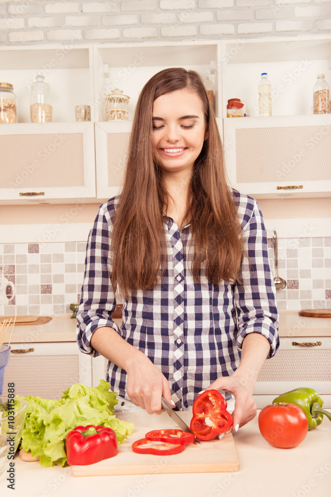 beautiful girl preparing vegetarian salad in the kitchen