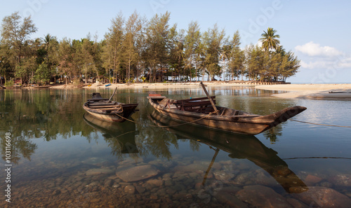 Two boats on the river beach with tropical forest near the sea