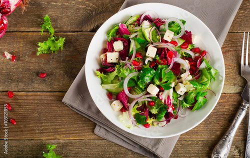 Fresh green salad with feta cheese and pomegranate.