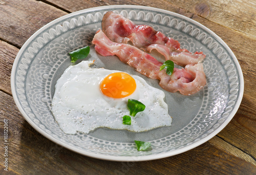 Fried egg with bacon slices for a healthy breakfast.