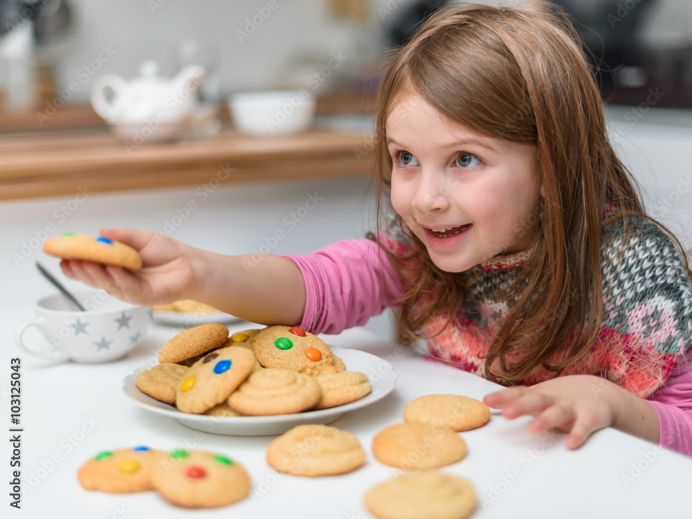 Happy Child by the Table Full of Cookies Giving One Happy Child by the Table Full of Cookies Giving One