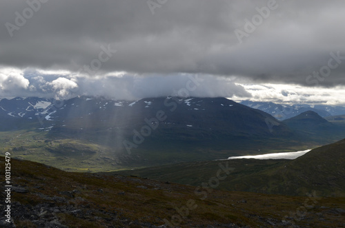 Dark clouds and sunshine over tundra in subarctic mountains  Swedish Lapland