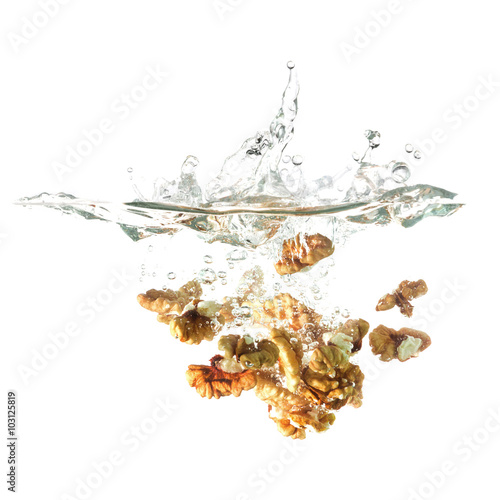 Walnuts splash on water, isolated on white background.